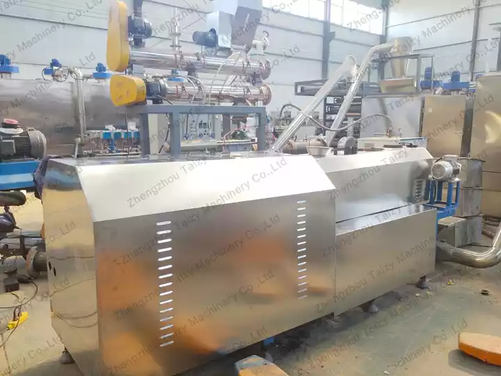 Twin screw extrusion machine for puffed cereal snack